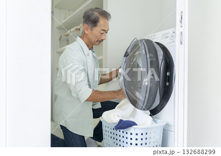 洗濯機に洗濯物を入れる60代の男性 132688299