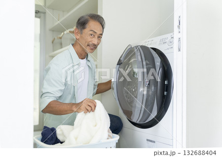 洗濯機に洗濯物を入れる60代の男性　カメラ目線 132688404