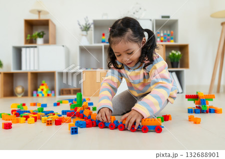 toddler girl playing building blocks or plastic bricks toy at home toddler girl playing building blocks or plastic bricks toy at home 132688901
