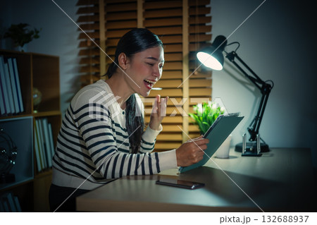 happy woman watching digital tablet at night 132688937