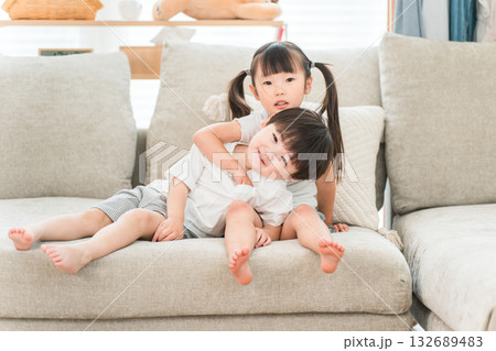 リビングのソファーにいる仲良しの兄妹 132689483