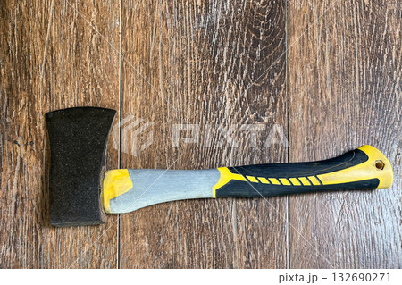 an axe with a fiberglass handle on a wooden background 132690271