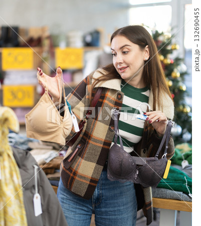 Uncertain young woman choosing bra in clothing store 132690455