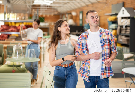 Interested couple looking for functional furniture in garden store 132690494