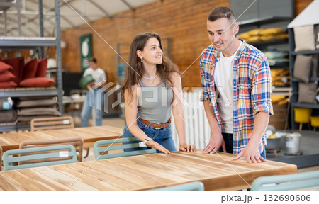 Interested couple looking for functional table in garden furniture store Interested couple looking for functional table in garden furniture store 132690606