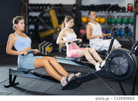 Young woman exercising on rowing machine Young woman exercising on rowing machine 132690668