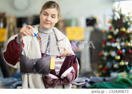 Young woman choosing bra set in Christmas boutique 132690673
