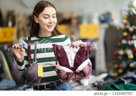 Positive young woman choosing bra in clothing store 132690707