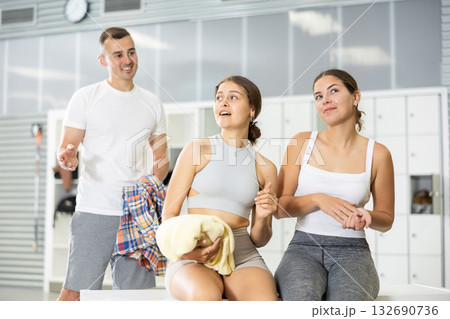 Young man intervenes in conversation between two girls in dressing room. 132690736