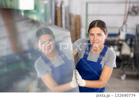 Female foreman inspecting plate glass cut to size Female foreman inspecting plate glass cut to size 132690774