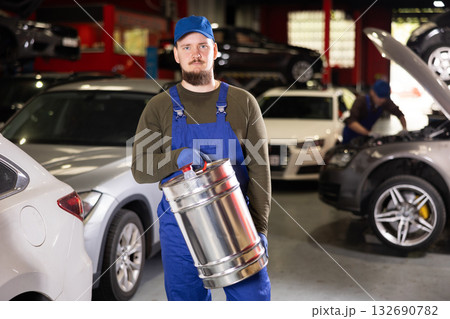 Young male mechanic with gasoline in container 132690782