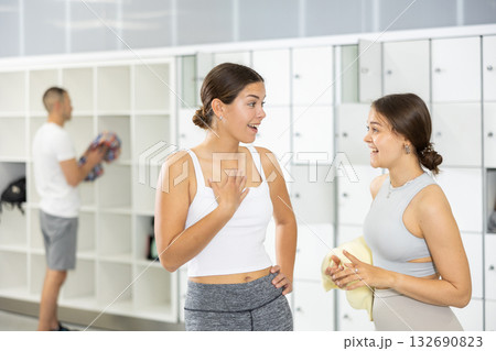 Female friends enjoying conversation in locker room of climbing gym 132690823