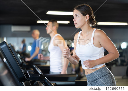 Young woman exercising on treadmill in gym Young woman exercising on treadmill in gym 132690853