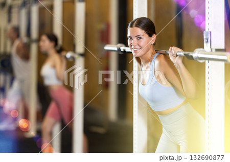 Young woman lifting barbell in gym 132690877
