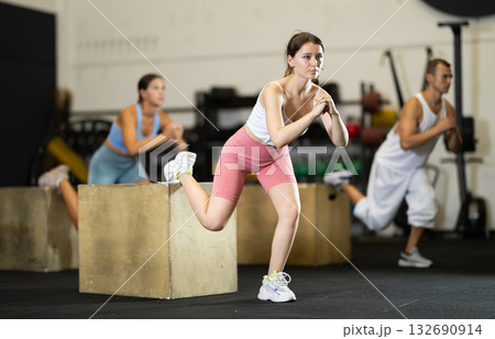 Young woman training with crossfit box Young woman training with crossfit box 132690914