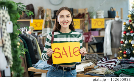 Young woman holding sale banner in clothing store 132690958