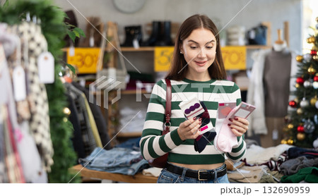 Woman client looks at products in store, choose closely socks Woman client looks at products in store, choose closely socks 132690959