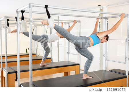 Young woman performing stretching exercises on pilates table Young woman performing stretching exercises on pilates table 132691073