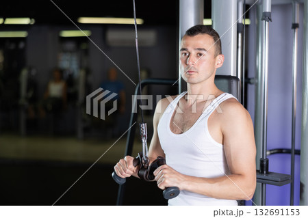 Man in sportswear training on rope loop simulator 132691153