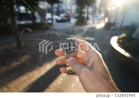 Wristwatch held up on urban street 132691495