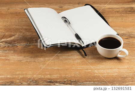 Notes and coffee on a wooden table in a quiet workspace 132691581