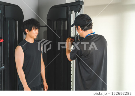 パーソナルジムで会員に個別指導するトレーナーの男性 パーソナルジムで会員に個別指導するトレーナーの男性 132692285