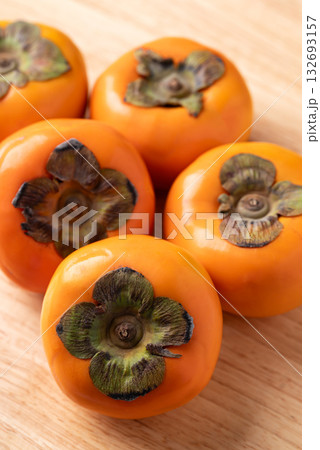Ripe persimmon fruit on wooden background, Autumn fruit Ripe persimmon fruit on wooden background, Autumn fruit 132693157
