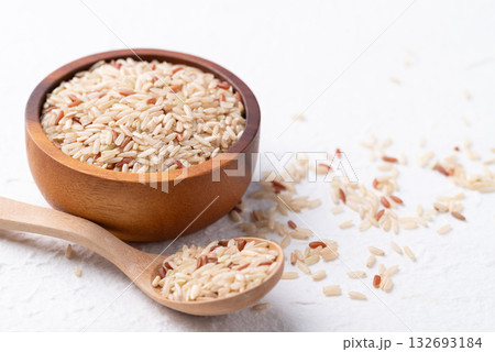 Thai brown rice seed (Highland wild rice) in wooden bowl and spoon on white background 132693184