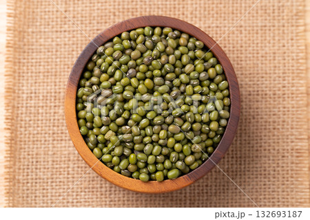 Mung bean in wooden bowl on burlap fabric background, Asian food ingredient, Table top view 132693187