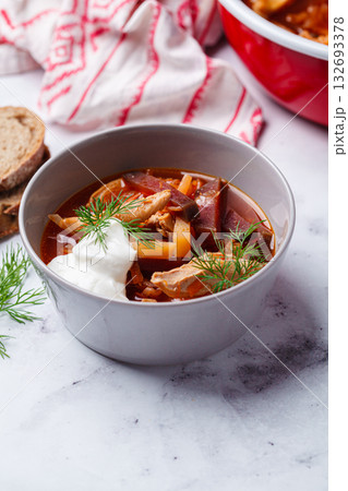 Classic homemade borscht with chicken in a grey bowl. Classic homemade borscht with chicken in a grey bowl. 132693378