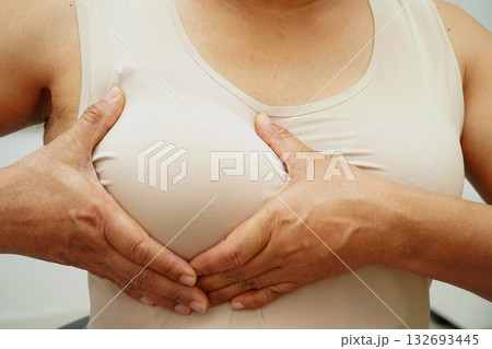 Asian woman self touching check lump or Breast cancer, Breast Self Exam. 132693445