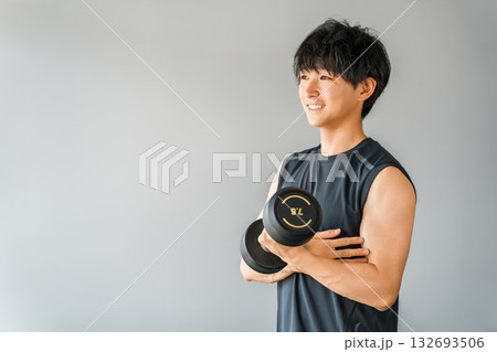 スポーツジムでダンベルを持って筋トレをする若いアジア人男性 スポーツジムでダンベルを持って筋トレをする若いアジア人男性 132693506