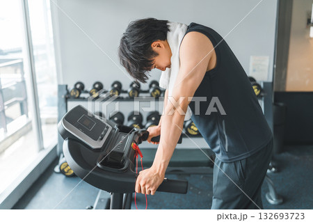 スポーツジムのウォーキングマシンで有酸素運動をする若いアジア人男性 132693723