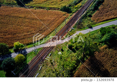 Aerial view of railway crossing in rural field landscape 132693978