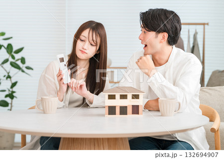 マイホームの家づくりで予算を検討する若い夫婦（予算オーバー,価格高騰,住宅価格） 132694907