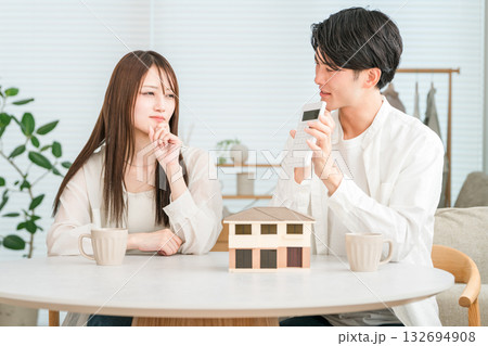 マイホームの家づくりで予算を検討する若い夫婦(予算オーバー,価格高騰,住宅価格) マイホームの家づくりで予算を検討する若い夫婦(予算オーバー,価格高騰,住宅価格) 132694908