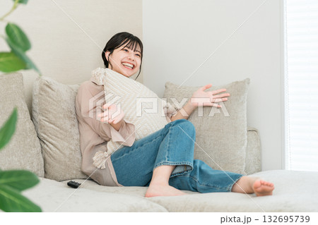 リビングのソファーに座りテレビ鑑賞,映画鑑賞する若いアジア人女性 リビングのソファーに座りテレビ鑑賞,映画鑑賞する若いアジア人女性 132695739