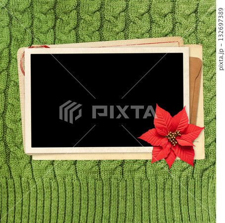 Christmas background with poinsettia, retro photo, vintage envelope, cards on wool sweater texture of green color. Nostalgic scrapbooking mockup template. Winter holiday backdrop. Copy space for text Christmas background with poinsettia, retro photo, vintage envelope, cards on wool sweater texture of green color. Nostalgic scrapbooking mockup template. Winter holiday backdrop. Copy space for text 132697389