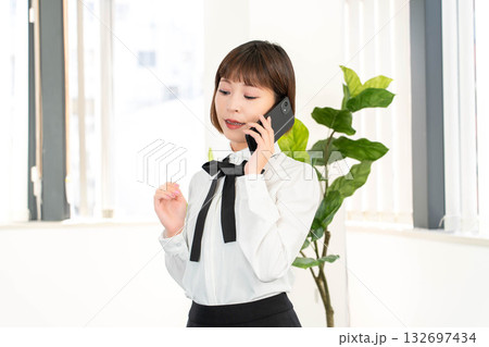 電話報告する秘書 132697434