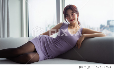 Woman in a purple dress relaxing on a sofa with a city view in the background during daytime Woman in a purple dress relaxing on a sofa with a city view in the background during daytime 132697603