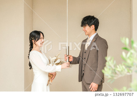 結婚式場,チャペルにいるウェディングベルの紐を持つドレス姿の新郎新婦 132697707