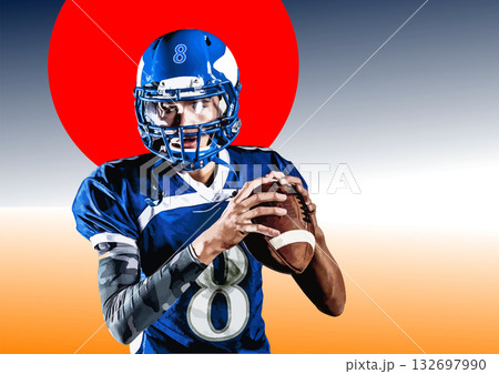 Confident and focused american football player wearing a blue uniform and holding a ball in his hands. No AI 132697990
