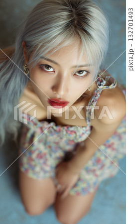 Korean woman with silver hair poses in floral dress, captured from above in a cozy indoor setting 132701493