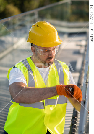 Engineer performing routine inspection of photovoltaic installation Engineer performing routine inspection of photovoltaic installation 132703171