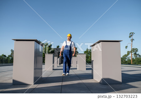 Male engineer wearing hard hat checking solar energy system 132703223