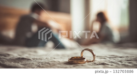 Couple struggles as man removes wedding ring in quiet bedroom on a rainy day Couple struggles as man removes wedding ring in quiet bedroom on a rainy day 132703886