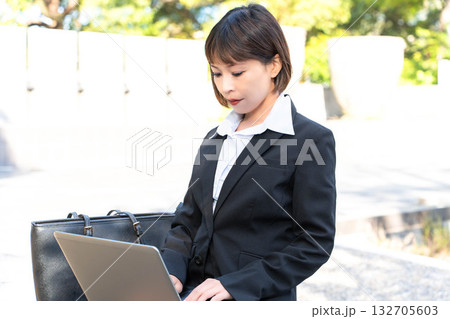 メールチェックをする外回りの女性社員 132705603