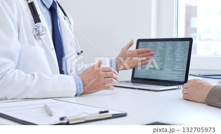 Close-up of a doctor reviewing digital test results with patient, discussing health findings on laptop screen during clinical consultation. Medicine and health care concept 132705973