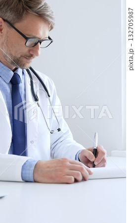 Middle aged doctor man writing a prescription and filling out medical records on a clipboard in an office setting, showcasing the essential aspects of healthcare and patient care. Medicine and health Middle aged doctor man writing a prescription and filling out medical records on a clipboard in an office setting, showcasing the essential aspects of healthcare and patient care. Medicine and health 132705987