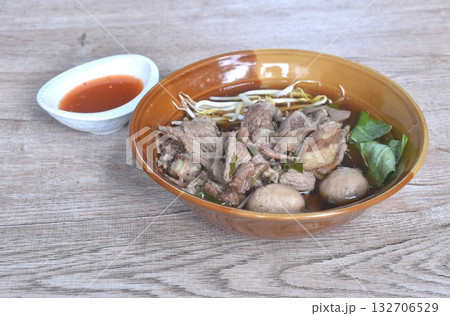 boiled braised pork meatball and tendon couple organ in herb brown soup on bowl dipping spicy chili sauce  132706529